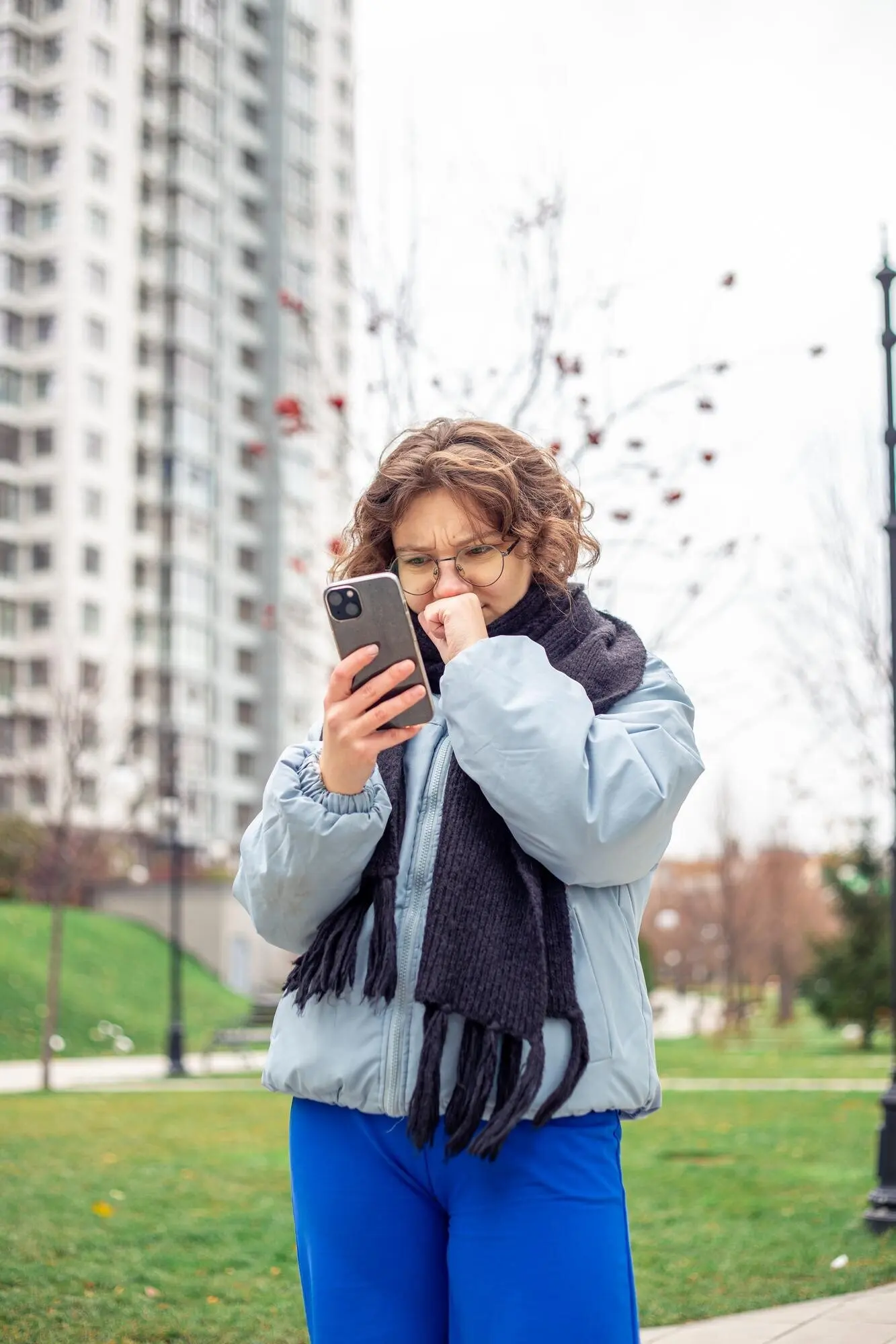 Mujer joven mirando el teléfono con sorpresa en la ciudad. Una mujer en una gran ciudad.
